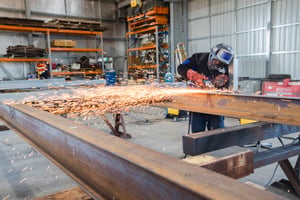 Worker welding steel in a workshop